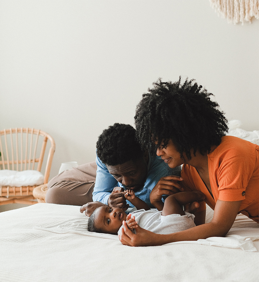 Un homme, une femme et un bébé sur un lit