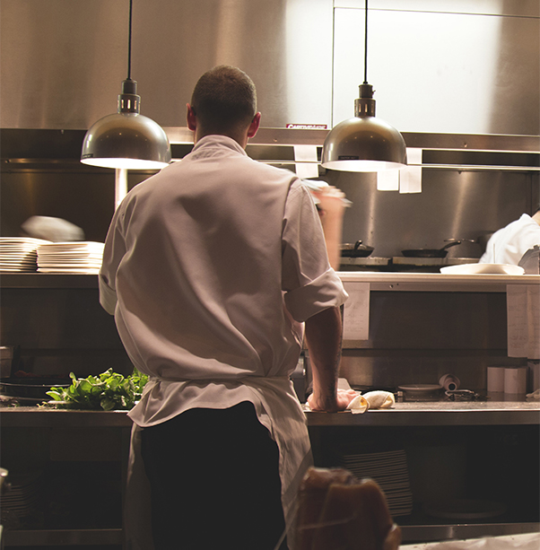 Un cuisinier de dos au travail dans une cuisine