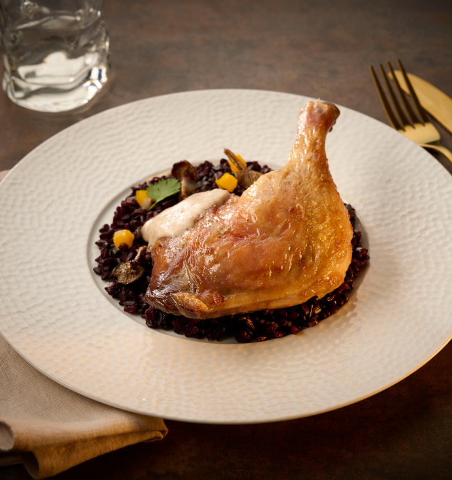 Cuisse de canard rôtie servie sur riz noir et champignons