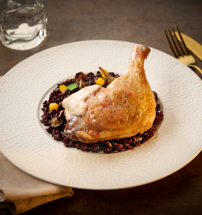 Cuisse de canard rôtie servie sur riz noir et champignons