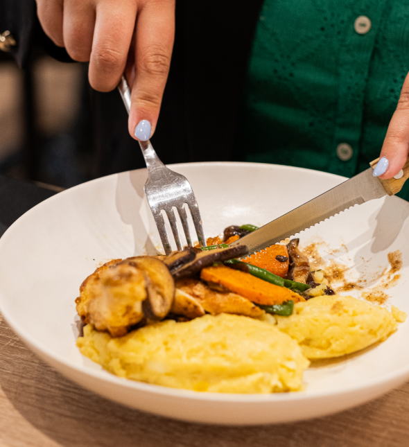 Assiette contenant un suprême de poulet accompagné d&#039;écrasé de pommes de terre avec des légumes glacés